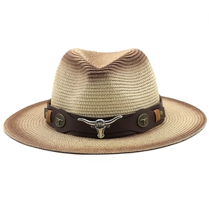 Détail d'un chapeau de paille de style western avec bandeau en cuir et emblème de tête de taureau