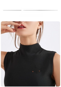Detail of colorful enamel cat brooch pinned on black knit high-neck sleeveless vest