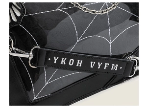 Detail of gothic ita bag featuring white spiderweb pattern and silver metal chain strap
