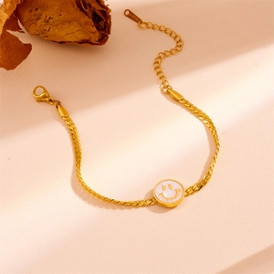 Close-up of golden stainless steel curb chain bracelet with smiley face charm and S-Steel tag