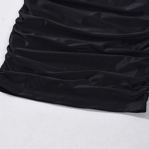 Detailed close-up of black ruched fabric texture with elastic pleated design and subtle sheen