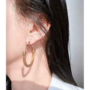 Golden oversized hoop earrings featuring a sophisticated woven metallic mesh texture