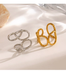 Detailed close-up of gold and silver irregular oval open rings with water ripple shadows