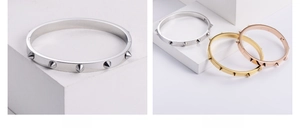 Detailed close-up of 18K gold plated rivet bangles in silver, gold and rose gold colors