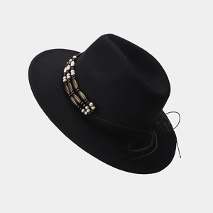Detalle del sombrero Fedora negro con banda de cuentas de madera y textura de fieltro