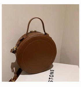 Detailaufnahme einer runden braunen Vintage-Lederhandtasche mit glatter Oberfläche