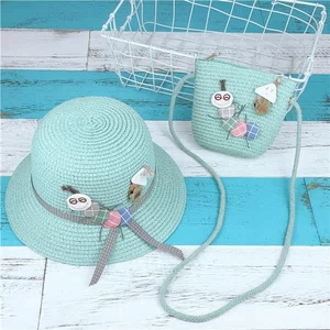 Detail of mint green straw sun hat and matching crossbody bag with cartoon decor