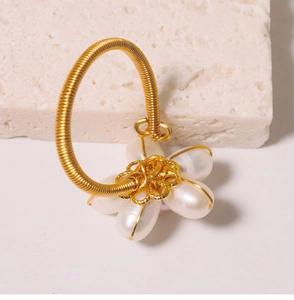 Macro shot of handmade gold wire ring with fresh water pearl flower detail on a stone