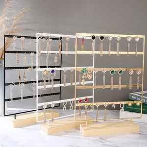 Three-tier metal earring organizer stand with wooden base in black white and gold
