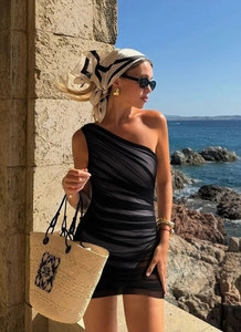 Detail of ruched black one-shoulder beach dress with sheer fabric texture