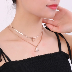 Double-layered rose gold stainless steel necklace with heart pendants on a female model