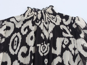 Detail of smocked high collar on chiffon dress with black and white abstract print
