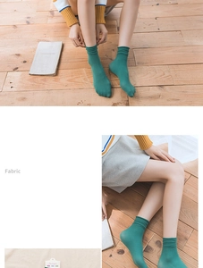 Close-up of retro dark green slouch socks with soft pleated cuffs on wooden background