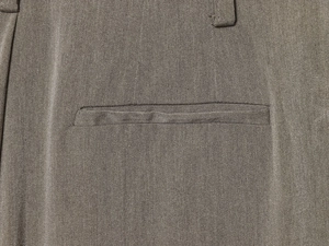 Détail de la poche arrière sur pantalon gris foncé montrant la texture du sergé