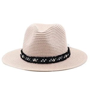 Detail of light beige straw fedora with checkered ribbon and silver metal studs