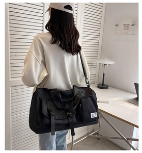 Detailed view of black nylon travel bag with adjustable strap shown in home setting