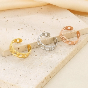Three chain-style adjustable rings in gold, silver, and rose gold on a stone prop