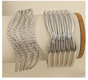 Detail of silver wavy multi-layer bangles with smooth and scale texture finish