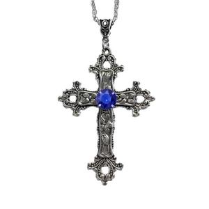 Macro view of silver gothic cross necklace with blue gemstone and floral relief