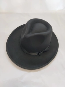 Close-up of black wide-brim felt fedora hat featuring matching ribbon and bow detail