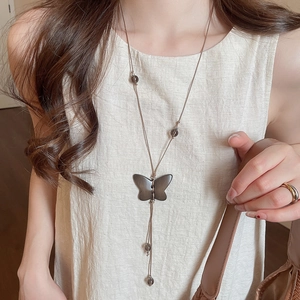 Gros plan du collier pendentif papillon marron translucide avec cordon tressé