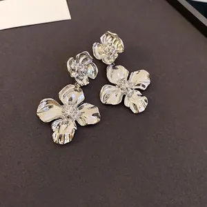 Silver flower drop earrings with hammered metal texture and vintage floral design