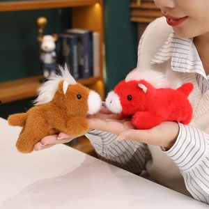 Cute magnetic plush pony dolls in red and brown colors held in hand as desktop decor