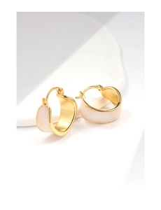 Detailed macro view of 18K gold plated hoop earrings with white enamel marble texture