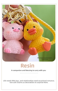 Macro shot of cute resin pink pig and yellow duck keychains with woven texture details