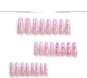 Macro detail of pink French press-on nails with heart and star patterns in 24 sizes