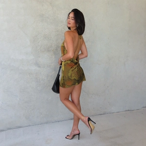 Close-up of yellow and green floral print on a backless satin halter mini dress