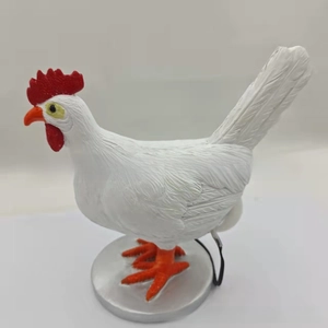 Detail of creative resin rooster lamp with feather texture and silver base for bedroom decor