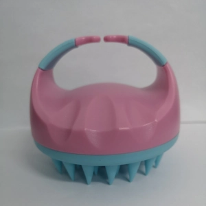 Pink and blue silicone scalp massager brush with ergonomic handle on white background