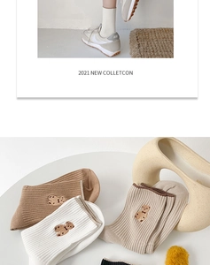 Détail de la broderie ours sur des chaussettes en coton aux tons terreux doux
