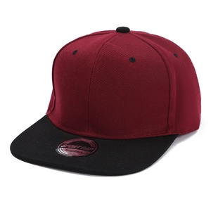 Detail of burgundy and black snapback cap with flat brim and sport cap sticker