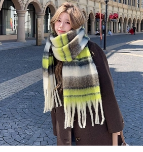 Close-up of yellow and green plaid knit scarf with soft fringe tassels on the edge