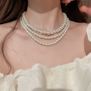 Detailed view of elegant multi-layer faux pearl necklace draped on a model's neck