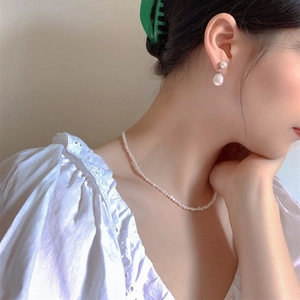 Baroque freshwater pearl necklace and drop earrings set worn by a fashion model