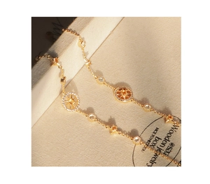 Detailed view of golden compass bracelet with zircon stones and yellow gem on jewelry box