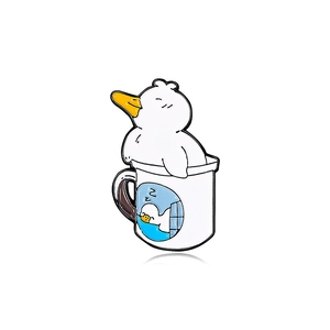 Cute enamel duck pin featuring a white duck in a cup with playful yellow and blue accents