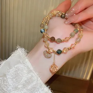 Multi-layer freshwater pearl beaded bracelet with heart pendant on a woman's wrist