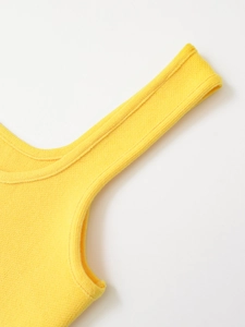 Detailed close-up of yellow knitted tank top featuring shoulder strap and ribbed neckline