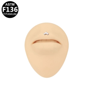 Detail view of ASTM F136 titanium labret piercing with three clear flower crystals