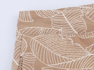 Detail of white leaf embroidery on khaki cotton-linen waistband for summer top