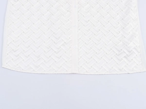 Détail d'une chemise en satin blanc avec texture tressée et fermeture à bouton