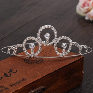 Detail of silver rhinestone princess crown with large gems on a vintage wooden box