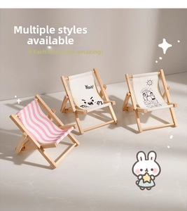 Detailed view of three mini wooden beach chair phone stands with striped and smile patterns