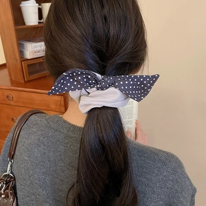 Detail of Korean style navy polka dot and grey fabric bow scrunchie on a ponytail