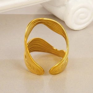 Close-up of a wide 18k gold-plated 304 stainless steel ring with sculptural S-shaped texture
