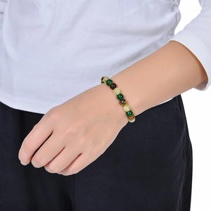 Close-up of tiger eye and citrine beaded bracelet on wrist showing texture